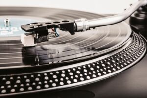 Close-up of a turntable tonearm and stylus playing a vinyl record