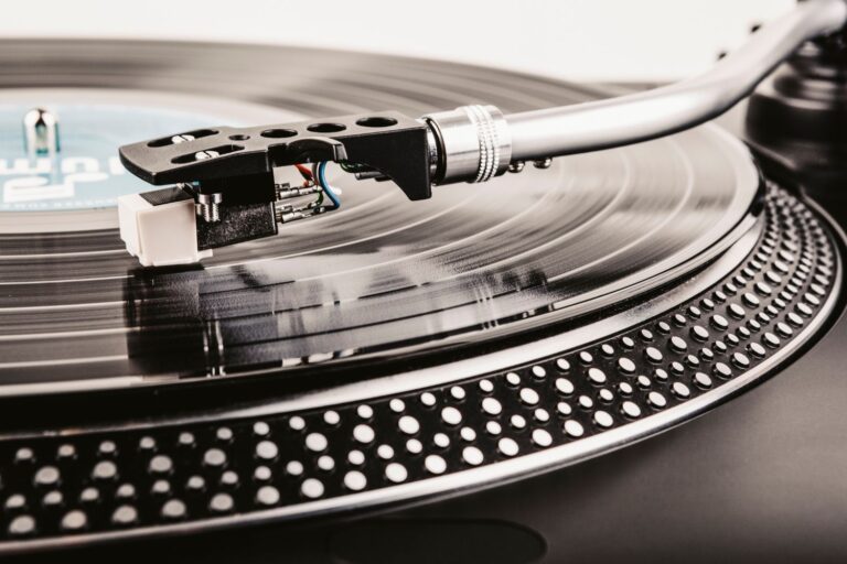 Close-up of a turntable tonearm and stylus playing a vinyl record
